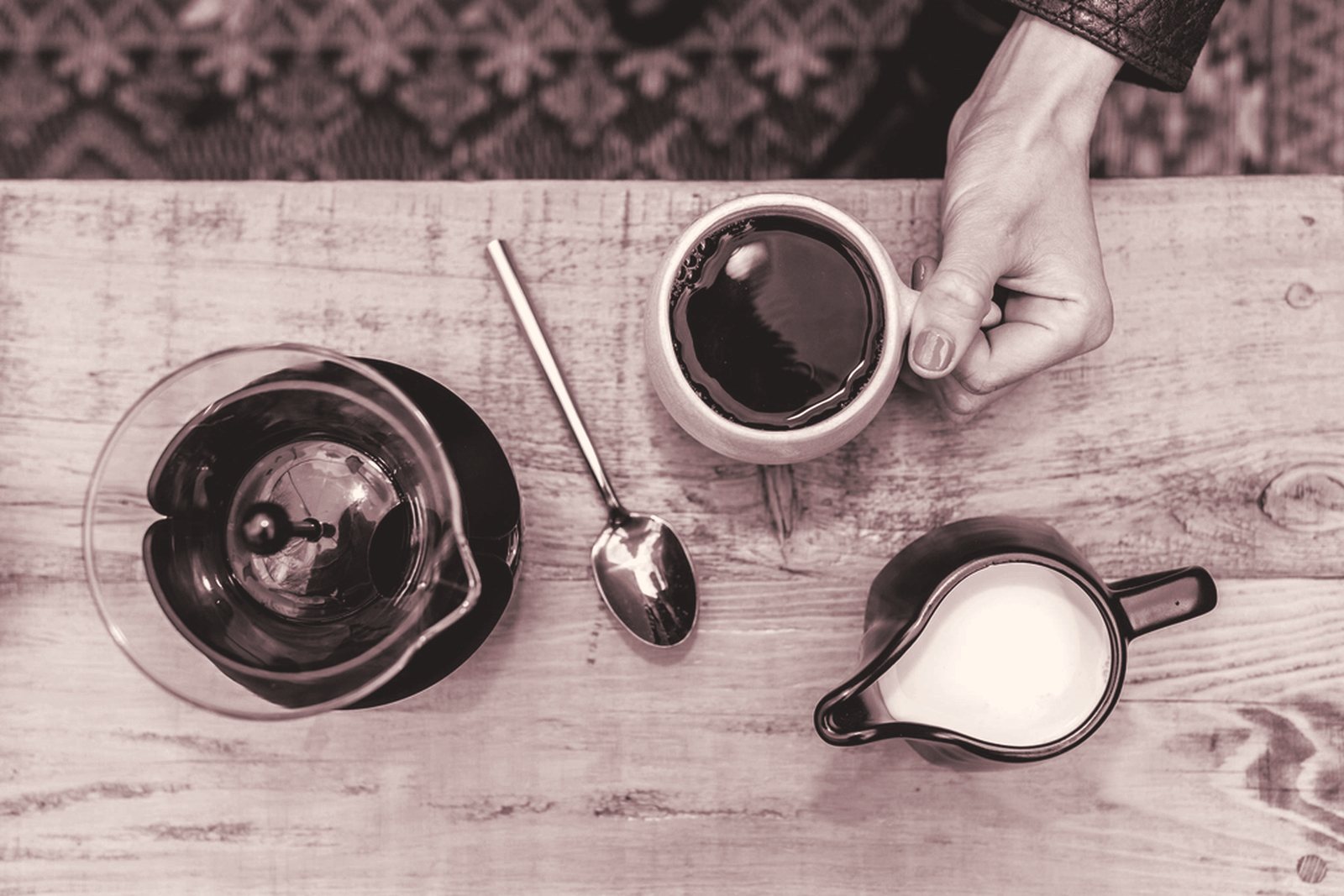 Coffee, milk and a spoon on a wooden table